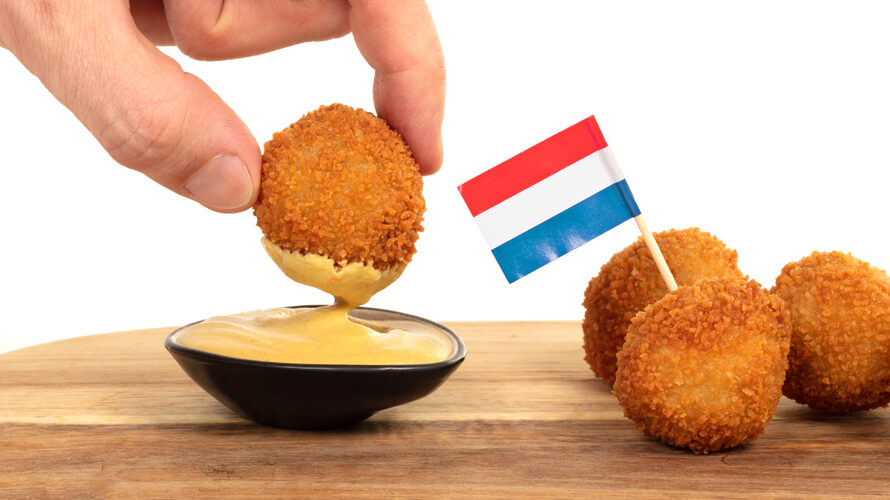 Dutch traditional snack bitterbal in a hand, isolated